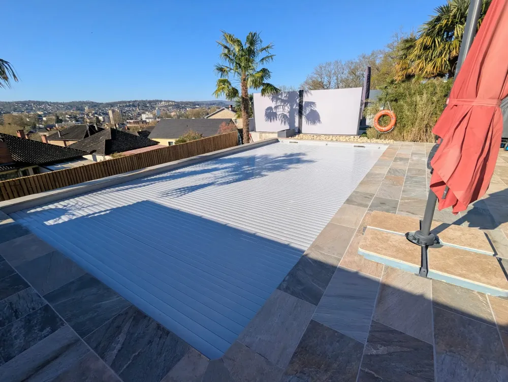 Piscine, ciel bleu et parasol rouge